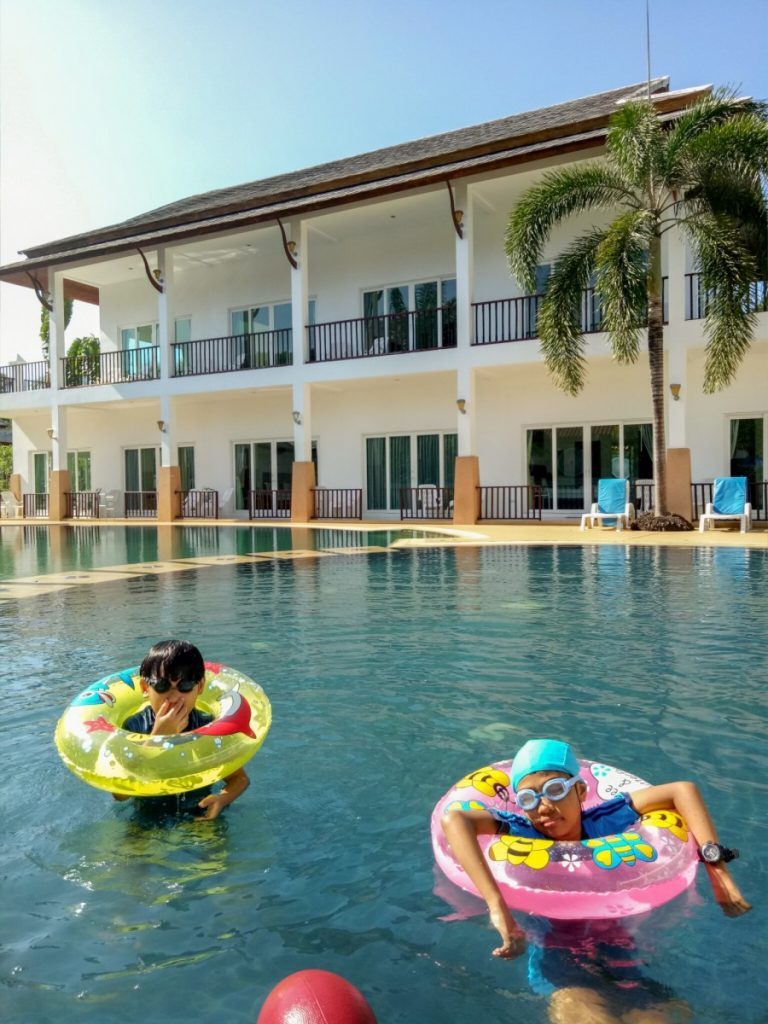two kids in the swimming pool at nadivana serviced apartment